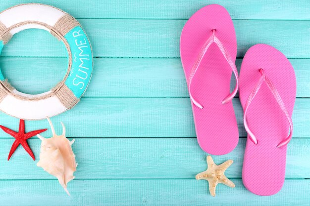 Photo bright flipflops on color wooden background