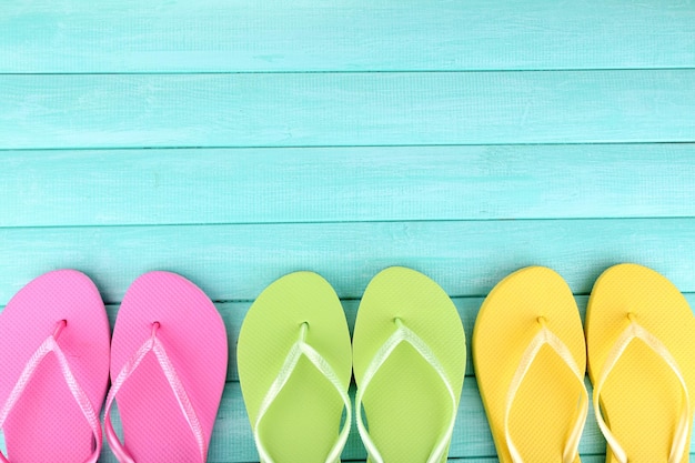 Bright flipflops on color wooden background