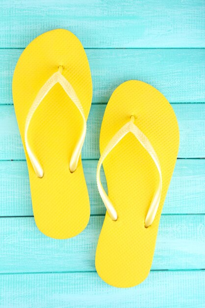 Bright flipflops on color wooden background