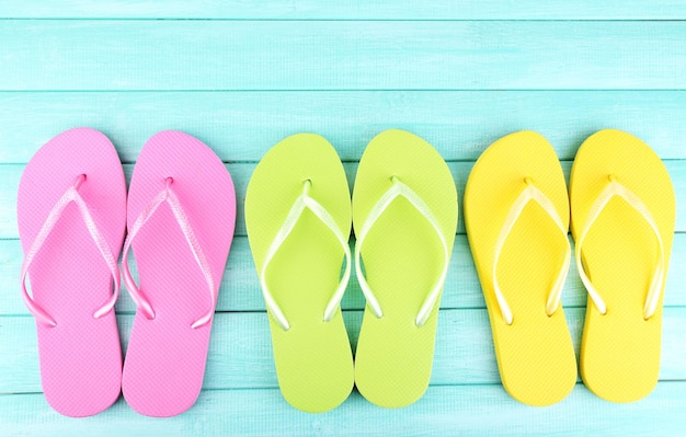 Bright flipflops on color wooden background