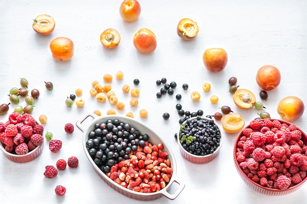 Bright fresh wild berries and peaches isolated top view. The concept of healthy eating.