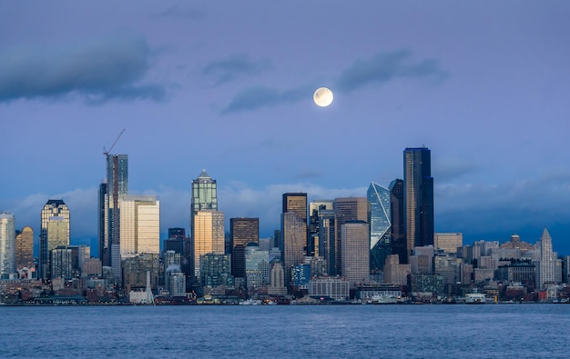 Photo a bright full moon shines over the seattle skyline