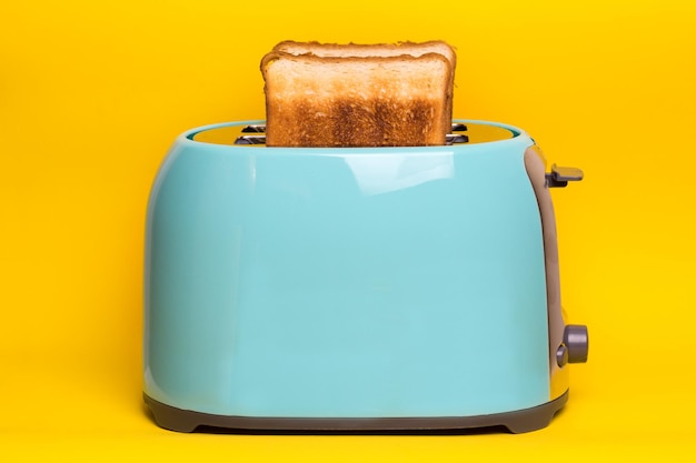 bright fun breakfast cyan color toaster on a yellow background