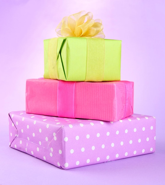 Bright gifts with bows on purple background