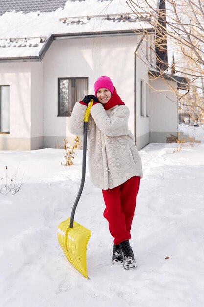 Foto una ragazza luminosa accanto alla casa in una giornata invernale soleggiata