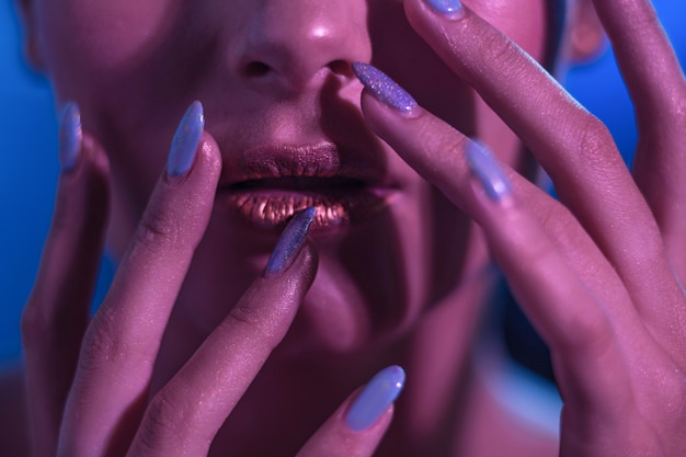 The bright golden lips of a girl model on a blue background.