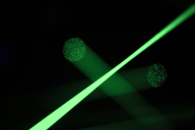 Luci laser al neon verde brillante illuminano l'oscurità creando linee