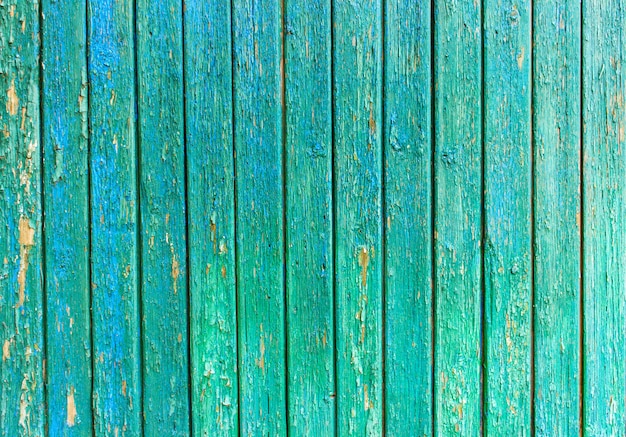 Bright green wood with peeling paint and vertical boards