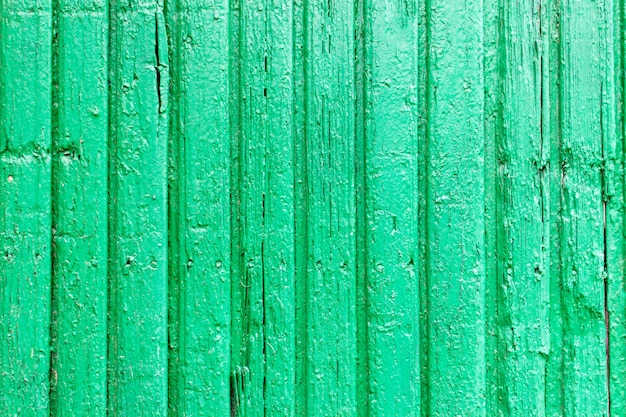 Bright green wooden background with peeling paint and vertical boards