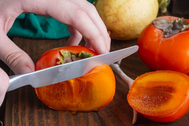 Bright juicy ripe and tasty orange persimmon Fresh useful autumn fruit on wooden closeup