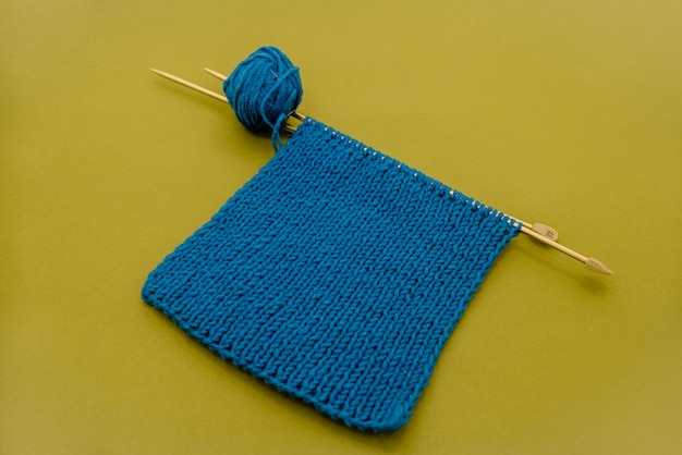 Bright knitted  scarf with knitting needles.