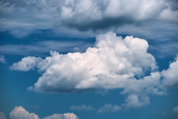 Bright landscape of white puffy cumulus clouds on blue clear sky.