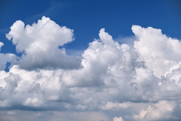 Bright landscape of white puffy cumulus clouds on blue clear sky