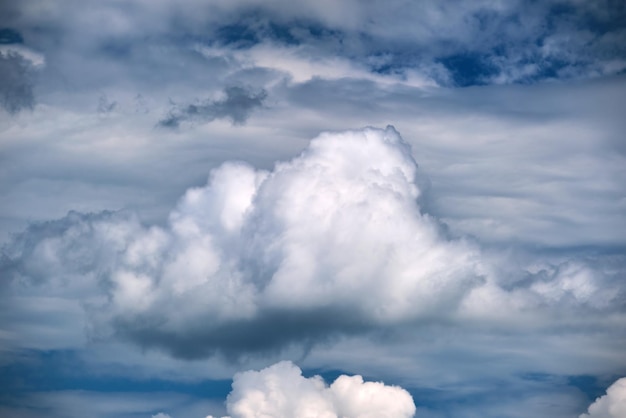 Bright landscape of white puffy cumulus clouds on blue clear sky