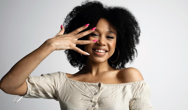 爪に明るいマニキュア アフロの外観の若い女性モデル 写真での写真撮影