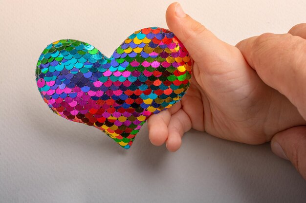 Bright multi color heart shaped object in hand