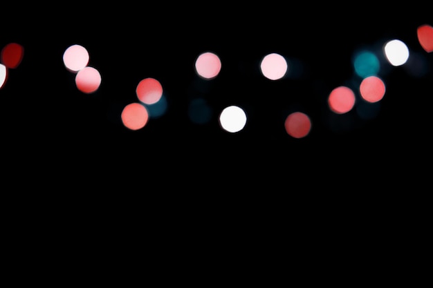 Bright multicolor blurry lights on a black background. Bokeh for post-processing photos, design.