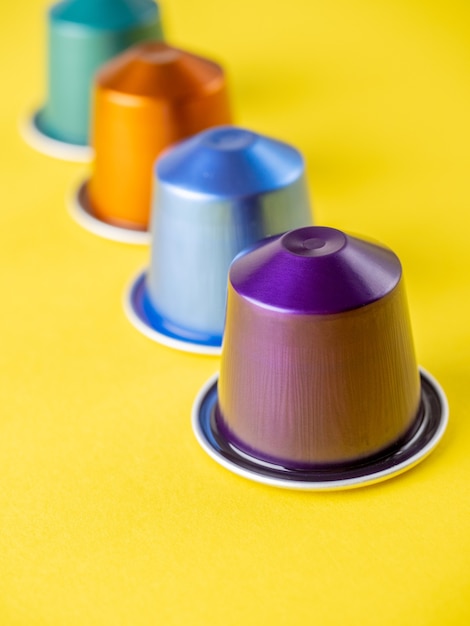 Bright multicolored coffee capsules for the coffee machine on a yellow background