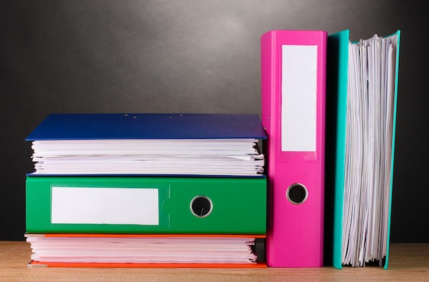 Bright office folders on wooden table on grey background