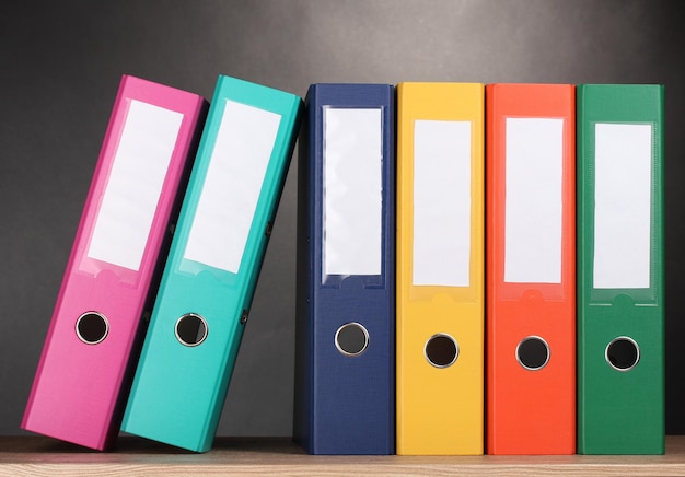 Photo bright office folders on wooden table on grey background