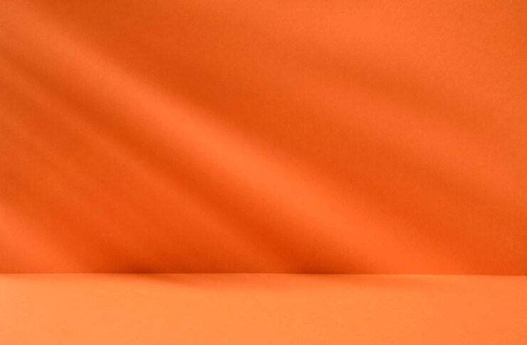 Photo bright orange background with plant shadows for product or cosmetics