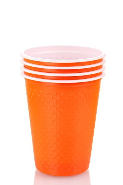 Bicchieri di plastica arancioni luminosi su bianco