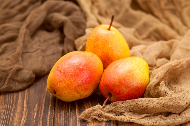 Photo bright orange ripe pears on a wooden brown