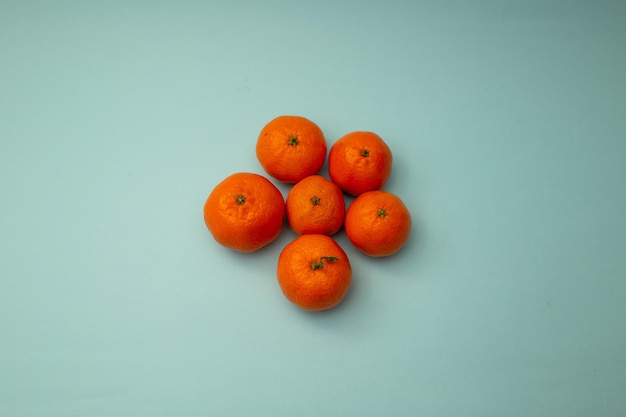 Bright orange tangerines lie on a blue background