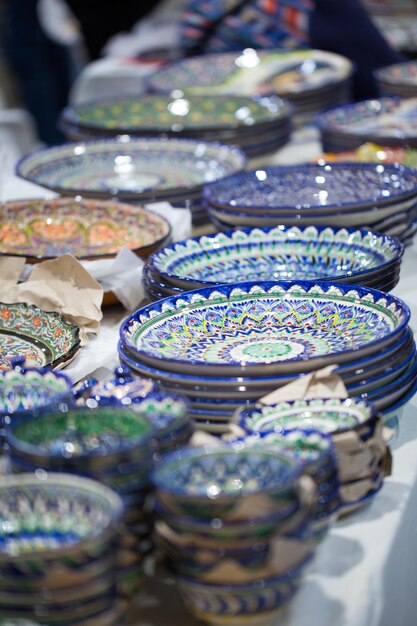 Bright oriental colored plates Authentic dishes handpainted in national style Beautiful bowls and plates in the oriental bazaar Bright background illustrating the national oriental style