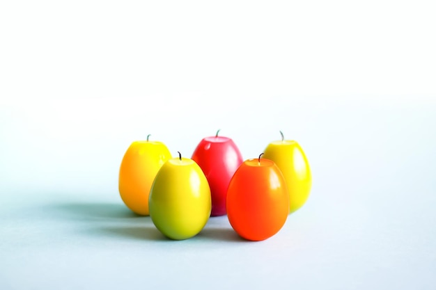 Bright paraffin candles in the shape of colorful Easter eggs on