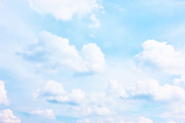 Bright pastel blue sky with white clouds - background and space for your own text