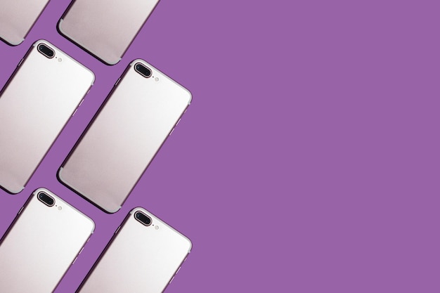 紫色の背景に現代の携帯電話と明るいパターン