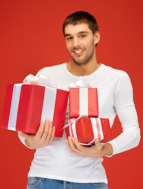 bright picture of handsome man holding many gift boxes.