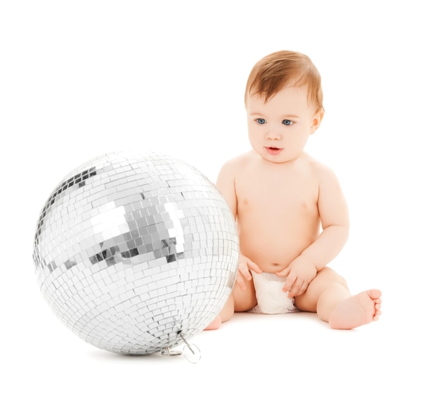 Immagine luminosa di un bambino felice che gioca con la palla da discoteca