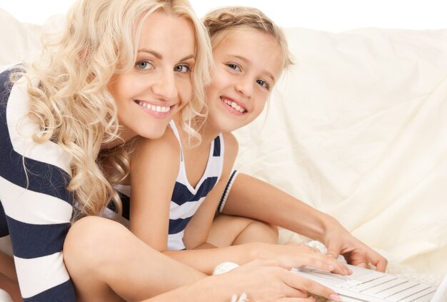 bright picture of happy mother and child with laptop computer (focus on woman)