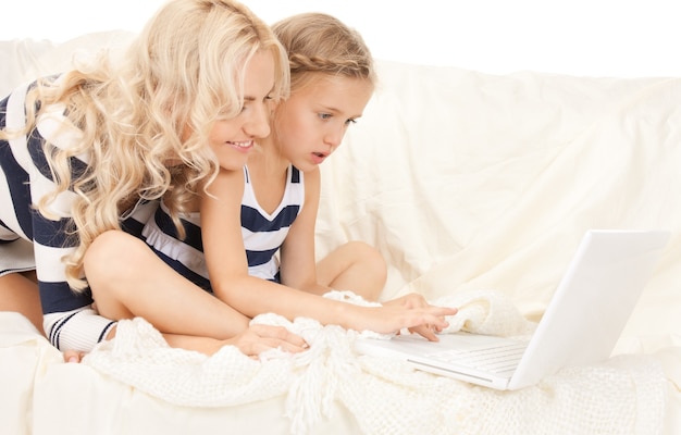 bright picture of happy mother and child with laptop computer