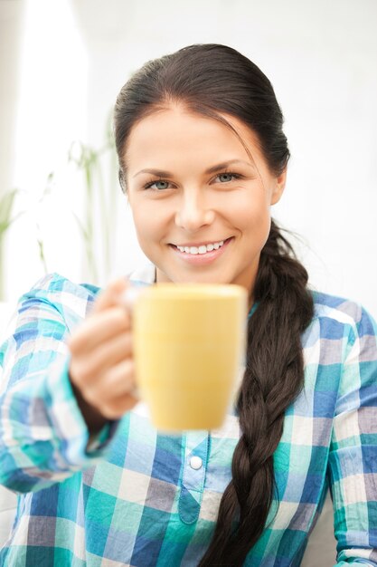 Foto immagine luminosa della bella casalinga con la tazza