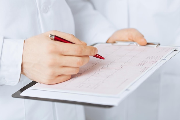 bright picture of male doctor hands holding cardiogram