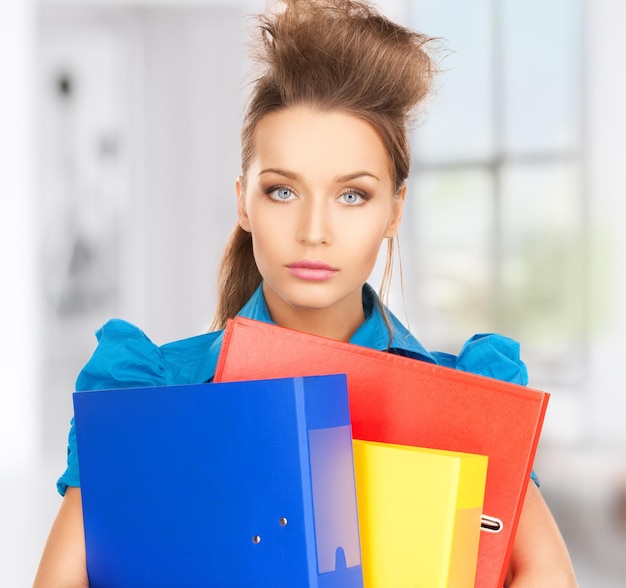 Bright picture of serious woman with folders