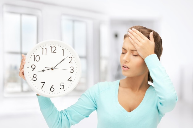 Foto immagine luminosa di una donna che tiene in mano un grande orologio