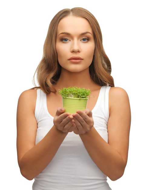 鍋に緑の草を持つ女性の明るい写真