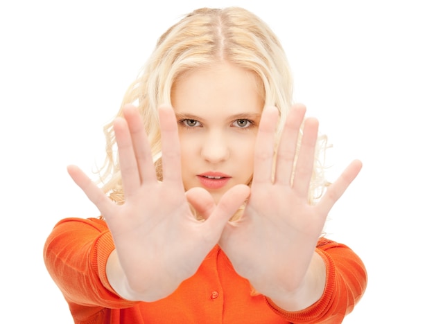 яркое изображение молодой женщины, делающей стоп жест