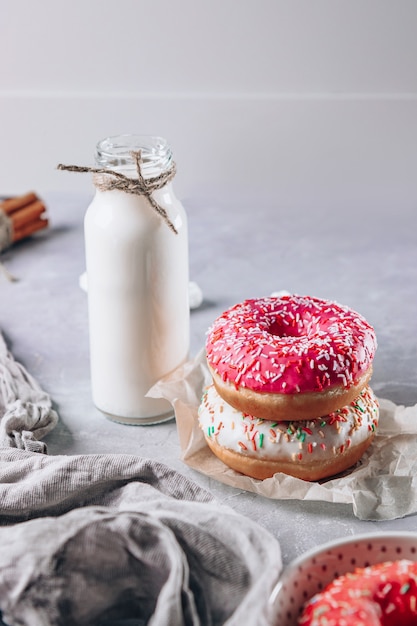 bright pink donuts and a bottle of milk