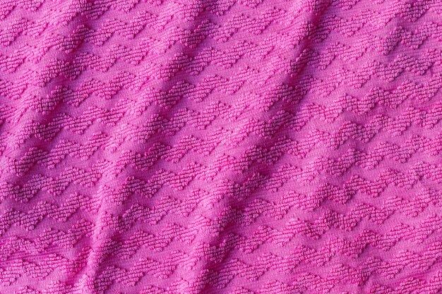 Bright pink fabric texture with zigzag. Crumpled rough textile
