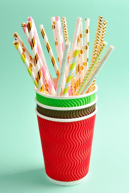 Bright pink and golden straws in paper cups