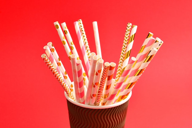 Bright pink and golden tubules in a paper cup. Copy space.