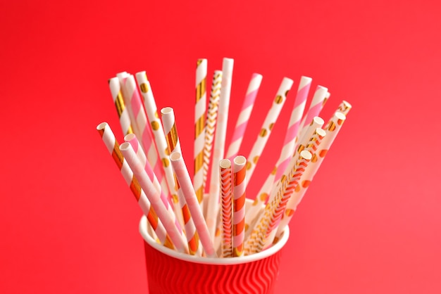 Bright pink and golden tubules in a paper cup. Copy space.