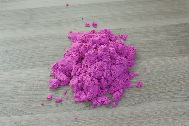 Bright pink kinetic sand in the hands of a child