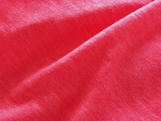 Bright pink or magenta polyester fabric wrinkled or folded carelessly Saturated background Defocused photo around the edges of the photo