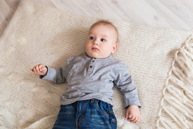 横たわっている愛らしい男の子の明るい肖像画